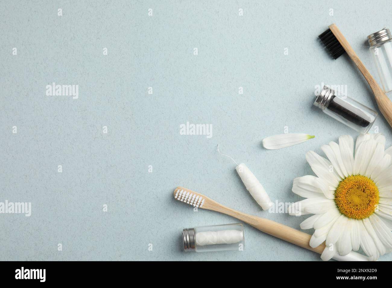 Composition de la couche plate avec des mousses dentaires biodégradables, des brosses à dents en bambou et de la camomille sur fond bleu clair. Espace pour le texte Banque D'Images