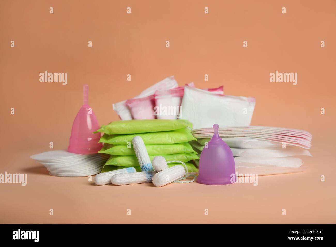 Coussinets menstruels et autres produits d'époque sur fond orange pâle Banque D'Images