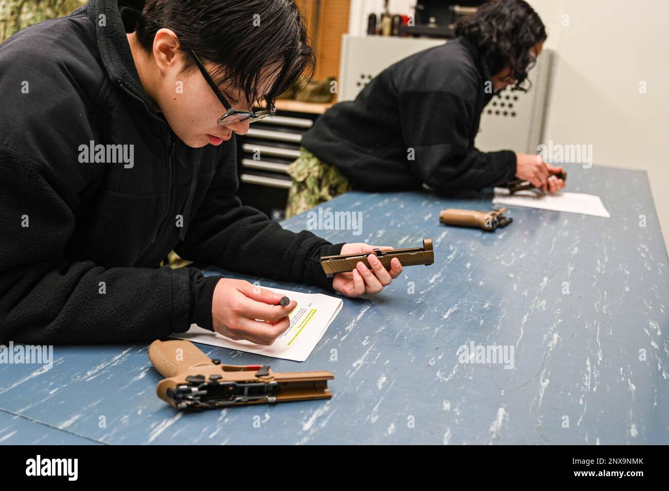 GREAT LAKES, Ill. (3 février 2023) Natalie D. Mendoza, étudiante au Commandement de l'entraînement des systèmes de combat de surface étudiants des Grands Lacs, assemble M18 pistolets à l'aide d'une fiche d'entretien à l'école « A » Gunner's Mate (GM). L’école « A » de GM offre aux marins candidats une formation technique sur l’entretien des armes, l’électricité, l’électronique et le fonctionnement des systèmes de lancement et des torpilles. Le M9 est un pistolet à percussion simple/double action à cadre en acier. Cela signifie qu'il s'agit d'un canon métallique plus lourd avec deux tirette de déclenchement différentes pour simple et double action. Inversement, le M18 est plus léger et ne se trouve pas dans Banque D'Images