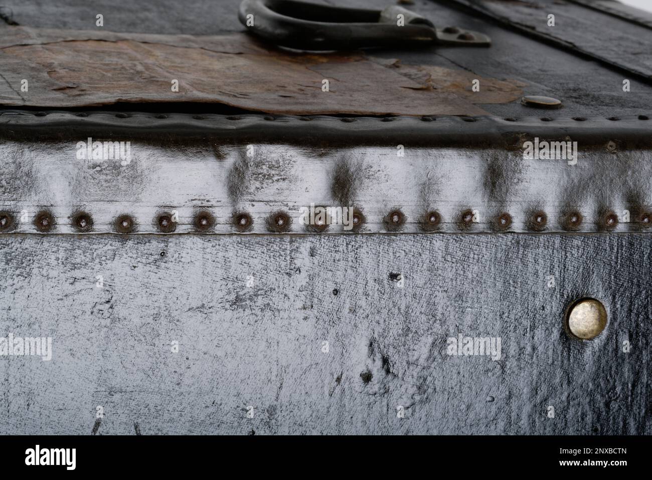 Gros plan sur des photos d'un coffre en bois à l'ancienne. Un coffre noir avec des coins renforcés en métal et des bords en cuir. Image d'arrière-plan. Banque D'Images