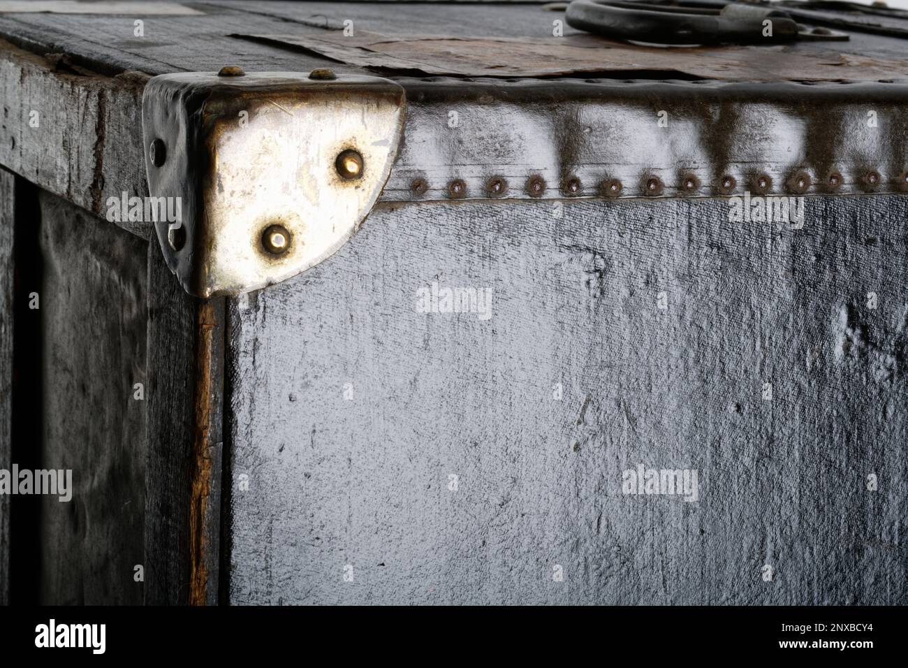 Gros plan sur des photos d'un coffre en bois à l'ancienne. Un coffre noir avec des coins renforcés en métal et des bords en cuir. Image d'arrière-plan. Banque D'Images