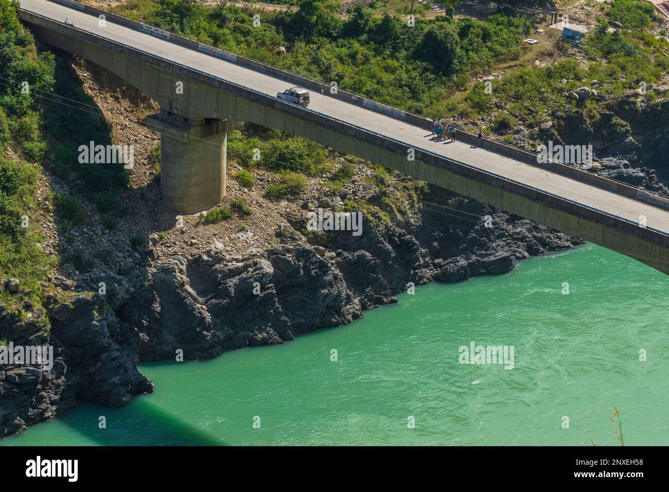 Ingénieurs réparant le pont sur le ruisseau de la rivière Alakananda avec la couleur bleu turquoise dot ci-dessous à Devprayag, conflunece Sainte. Une voiture passe. Inde. Banque D'Images
