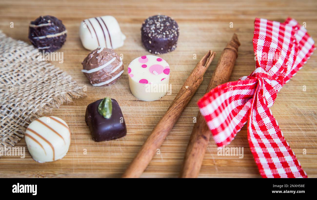 Pralines au chocolat avec bâton de cannelle et ruban de Vichy câblé. Banque D'Images