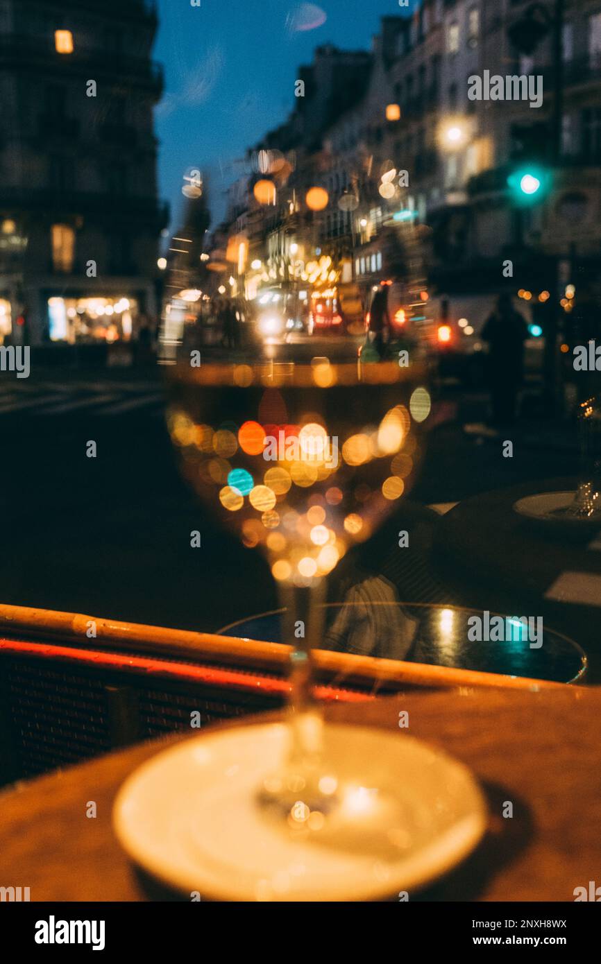 Paris, 08.02.23: Sortir, les lumières de la rue scintillent dans un verre de vin. Banque D'Images