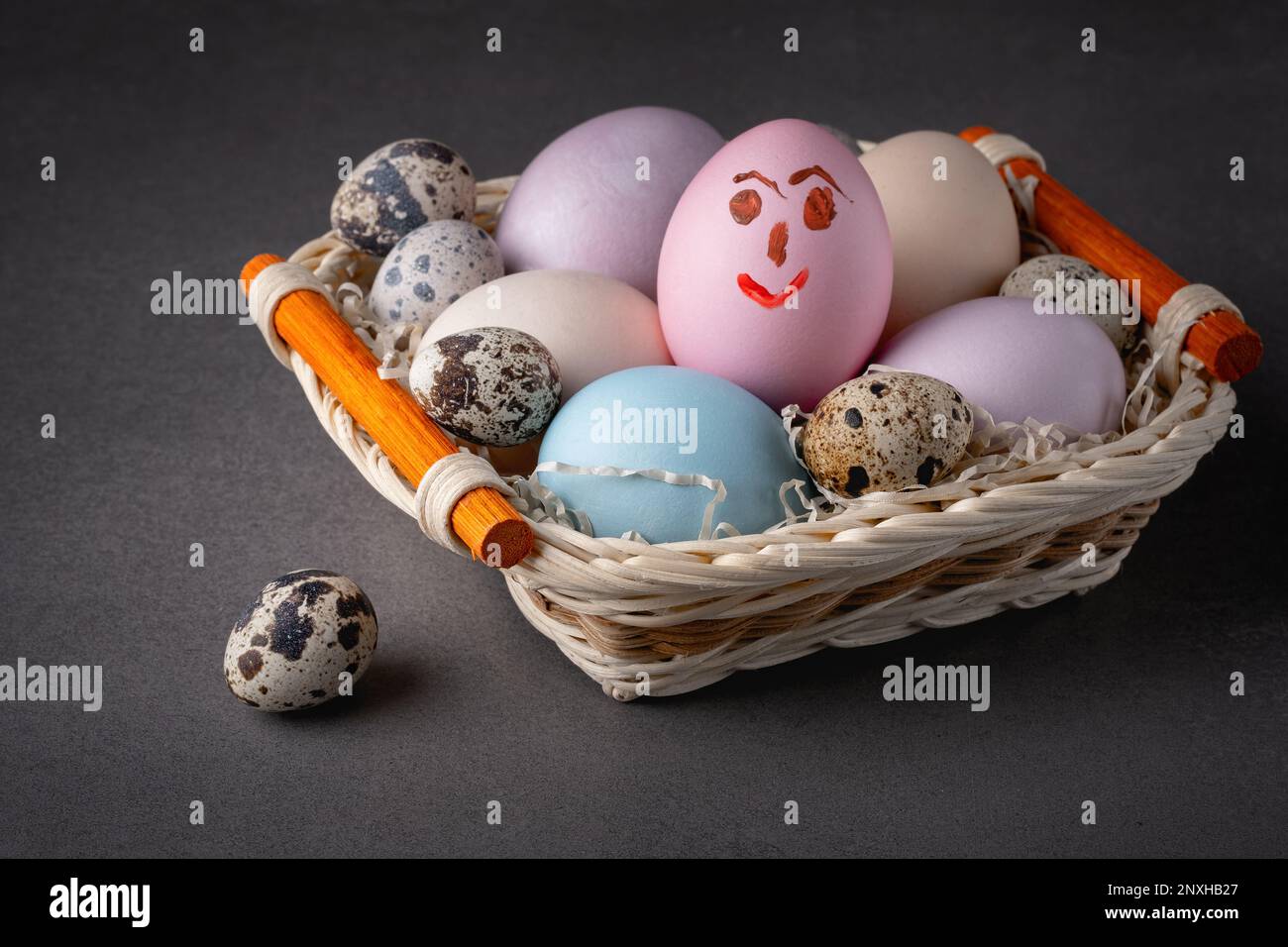Panier avec œufs de pâques sur fond gris Banque D'Images