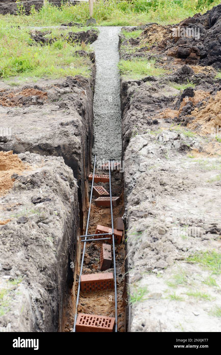 Le fond de la bande de remplissage avec du béton sur le site de construction. début de la construction d'une maison. Banque D'Images