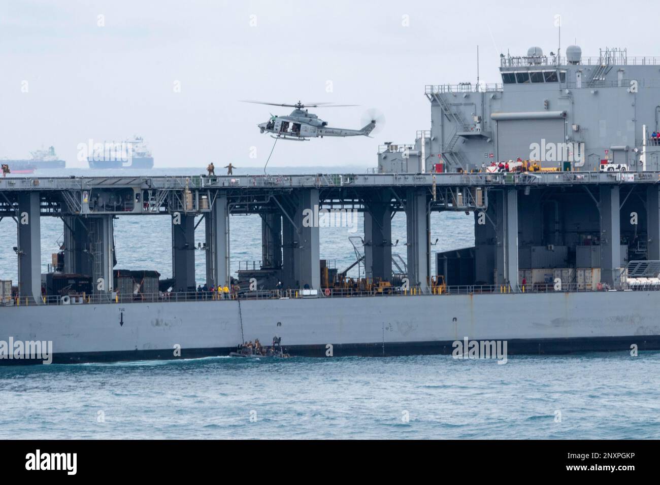 NATUNA SEA (7 janvier 2023) – Marines affectées à un peloton de la Force de RAID maritime (FRM) embarqué à bord d'un quai de transport amphibie USS Anchorage (LPD 23) Utiliser 11m bateaux gonflables à coque rigide (RIBs) et un UH-1Y Venom affecté au variable Tiltrotor Squadron (VMM) 362 pour monter à bord de la base mobile expéditionnaire Lewis B. Puller-Class USS Miguel Keith (ESB 5) pour une visite, un exercice de formation à bord, à la recherche et à la saisie (VBSS), janvier 7. La capacité de fonctionner de façon transparente et simultanée sur la mer, à terre et dans l'air représente la valeur unique de la capacité amphibie fournie par l'équipe ARG/MEU. Le Makin est Banque D'Images