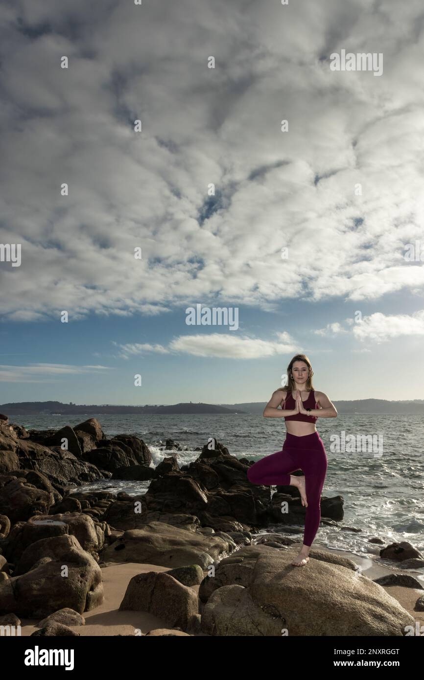 Trouvez votre paix intérieure : femme blonde pratiquant le yoga sur la plage Banque D'Images