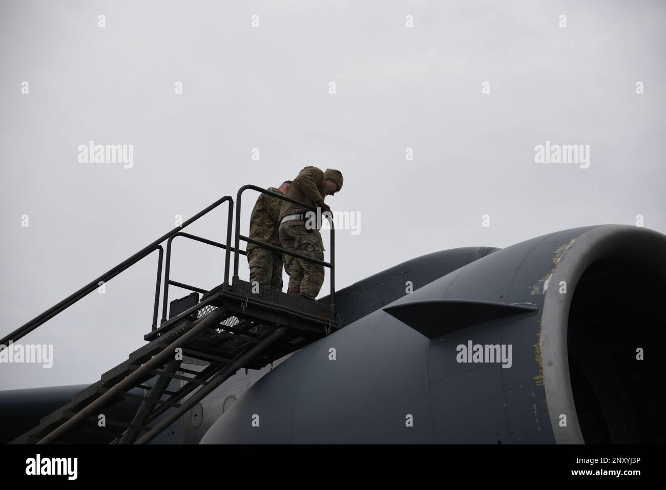 ÉTATS-UNIS Air Force Airman 1st classe Travis Miller, à gauche, compagnon électrique et environnemental, et Tech. Le Sgt Sean Monaghan, NCO en charge de l'électricité et de l'environnement, tous deux avec l'escadron de maintenance des aéronefs 62D, inspecte un C-17 Globemaster III pour évaluer le type de réparations à effectuer à la base conjointe Lewis-McChord, Washington, le 3 février 2023. L'une des responsabilités des aviateurs électriques et environnementaux est de s'assurer que le circuit de refroidissement du moteur fonctionne correctement. Banque D'Images