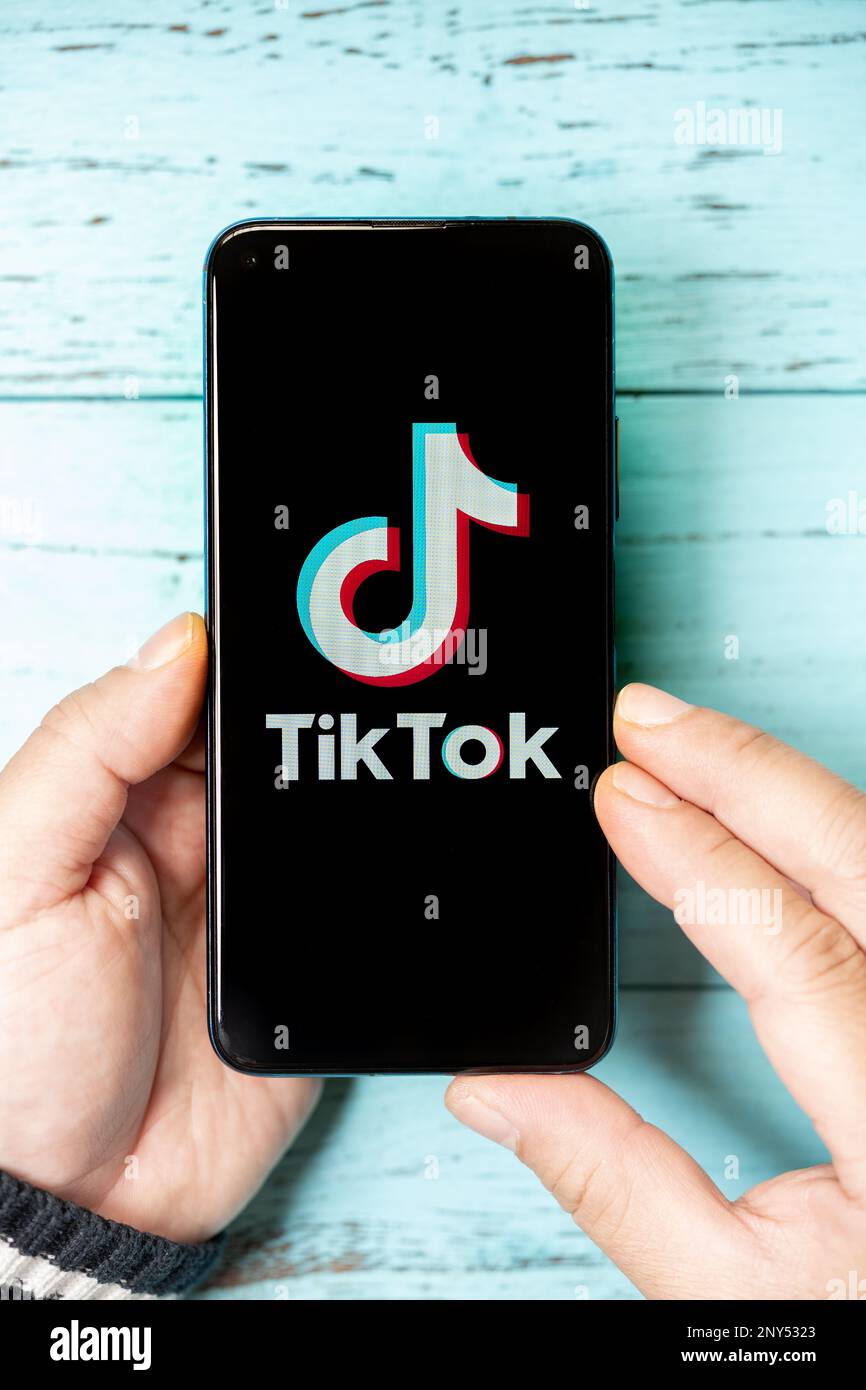 Zhongshan China-2 mars,2023:man tenant un mobile avec un grand logo TikTok à la composition verticale. Banque D'Images