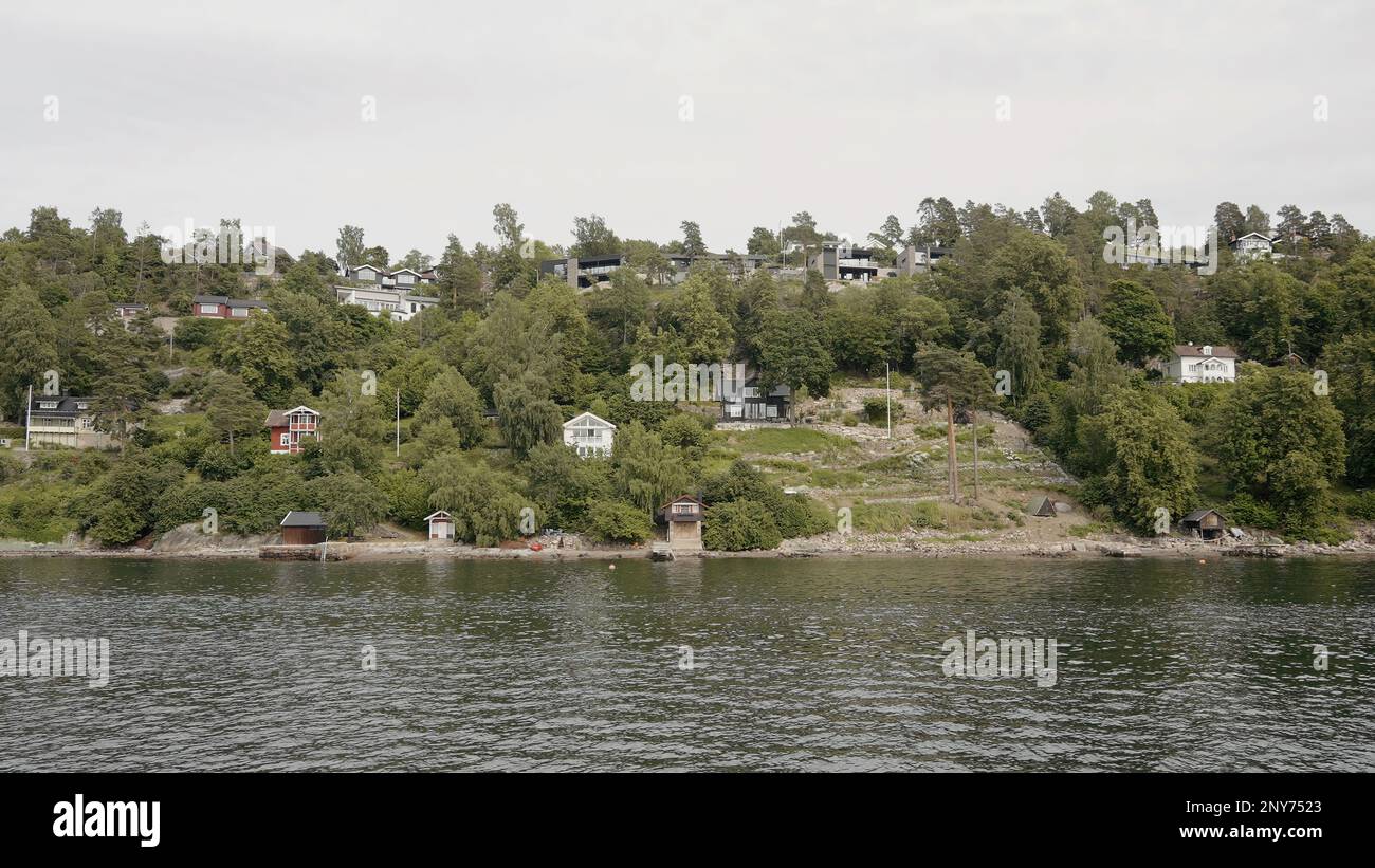 Paysage naturel avec rivière ondulée et maisons au bord de la côte. Action. Campagne, vue sur la rivière sur une petite ville et arbres verts Banque D'Images