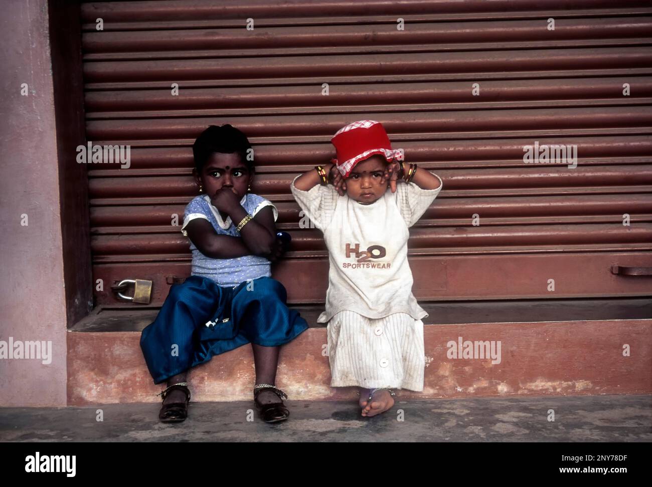 Les enfants sont assis devant la boutique fermée, Kerala, Inde Banque D'Images
