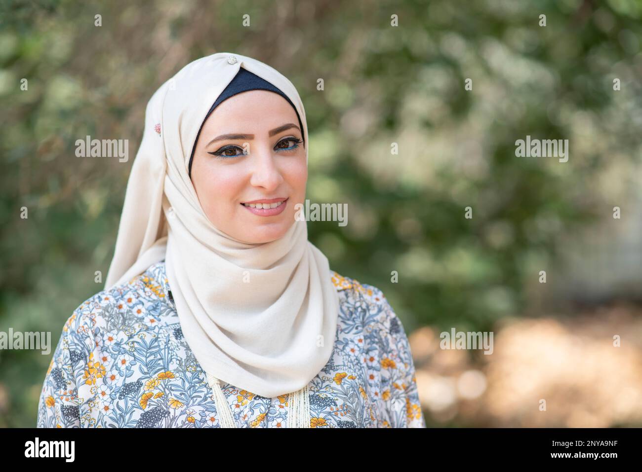 Belle femme musulmane regardant l'appareil photo souriant à l'extérieur Banque D'Images