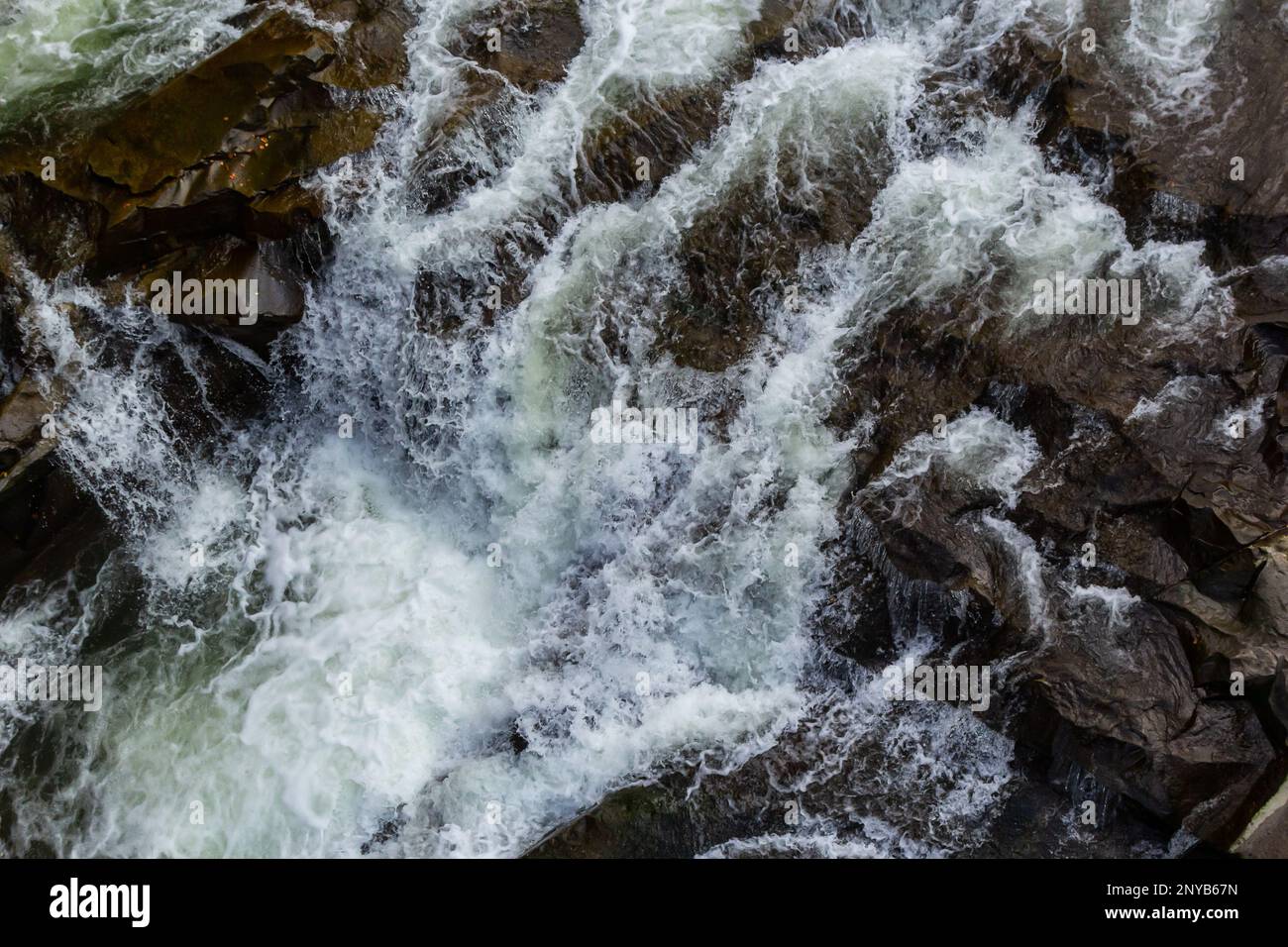 rapides de rivières de montagne avec de l'eau rapide et de grands rochers rocheux. Débit rapide d'une rivière de montagne au printemps, gros plan. Banque D'Images