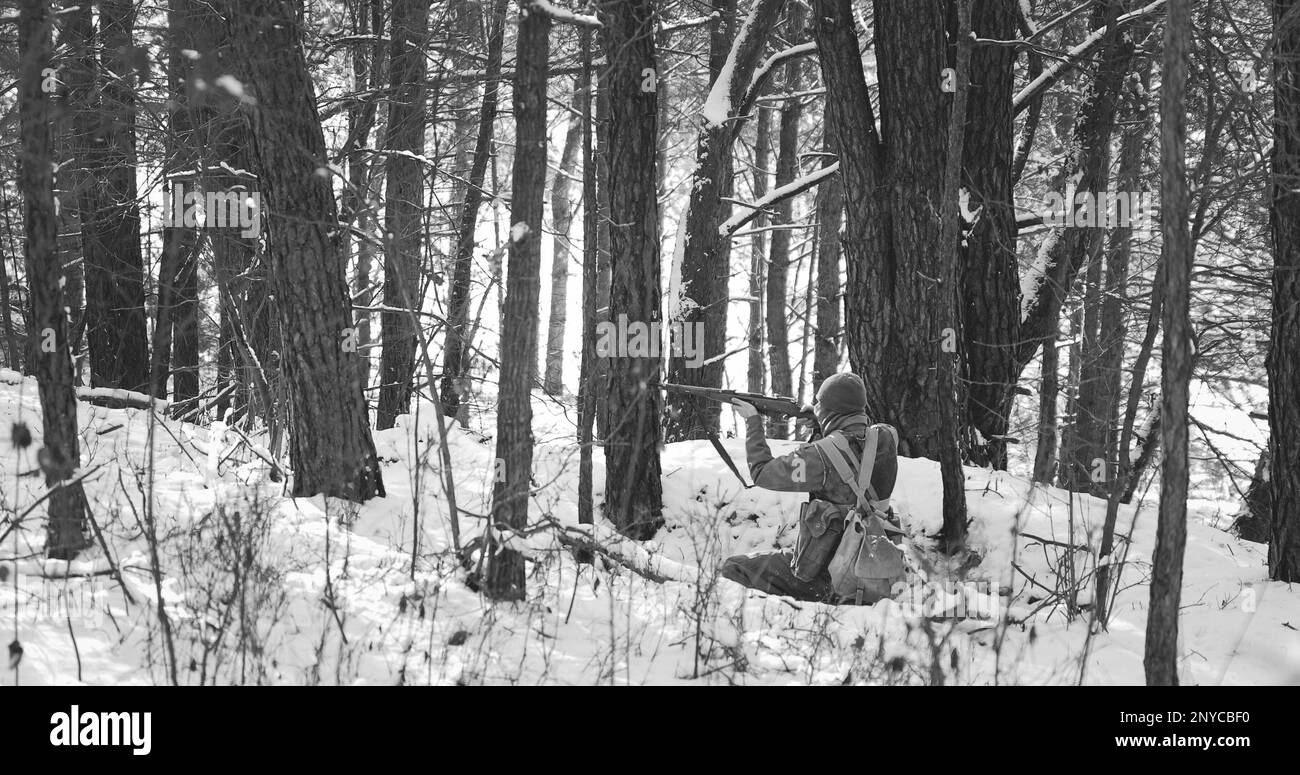 Réacteur habillé comme soldat américain de l'infanterie des États-Unis d'infanterie de la Seconde Guerre mondiale tir de fusil dans la forêt d'hiver. Reconstitution historique Banque D'Images