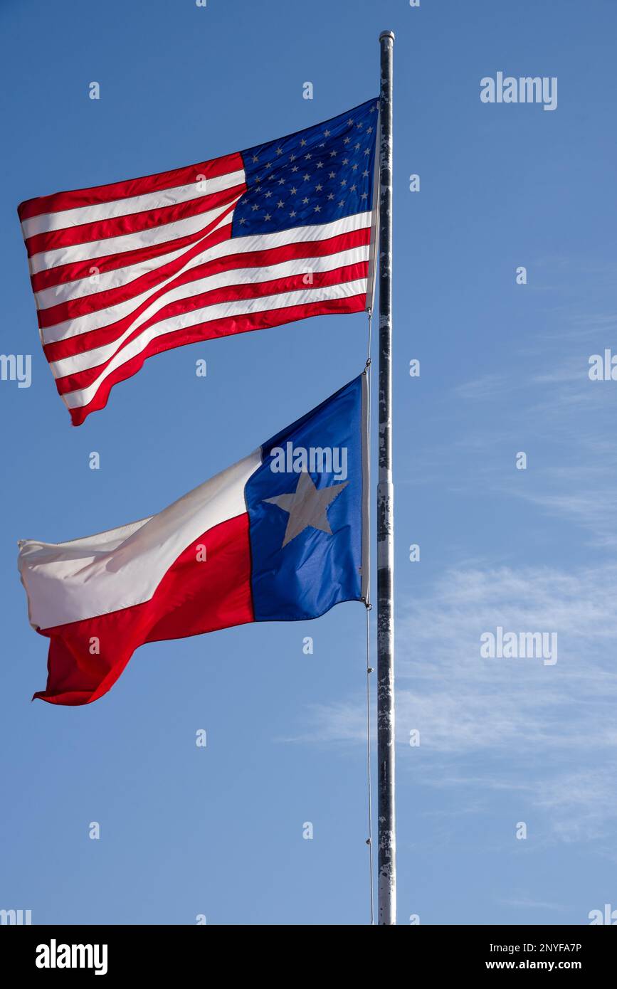 Drapeau américain et drapeau de l'État du Texas sur un mât de drapeau volant dans la brise, Texas, États-Unis. Banque D'Images