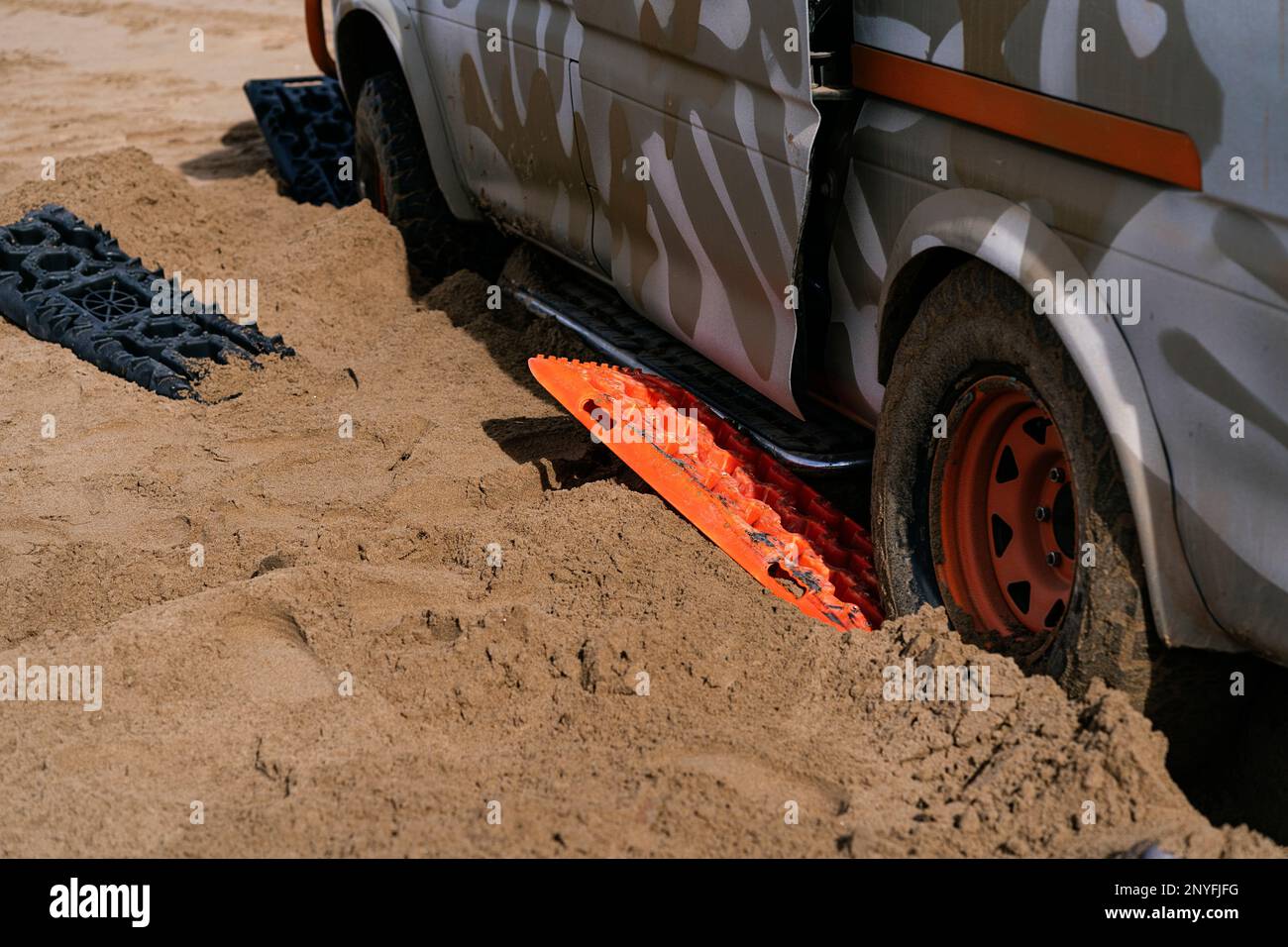 Automobile contemporaine coincée dans un désert sablonneux, debout sur des équipements spéciaux et débardage en Mauritanie Banque D'Images
