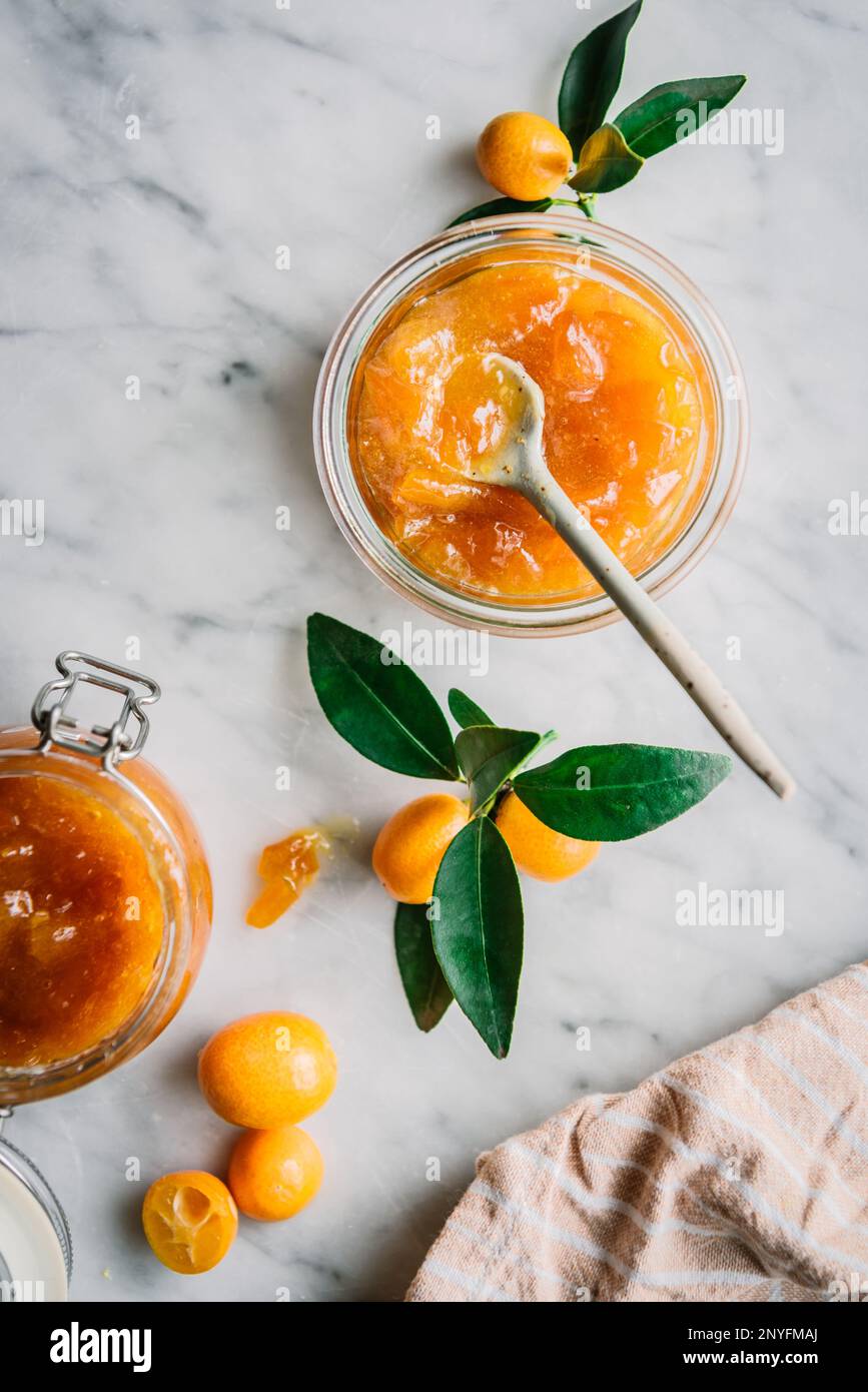 Vue de dessus du bol en verre avec confiture de kumquat fraîche avec une cuillère sur la table sur fond gris foncé flou Banque D'Images