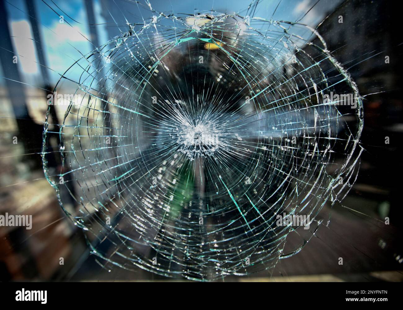 Fenêtre avec effet d'endommagement comme filet de cercles et de lignes de fissures sur la surface en verre translucide Banque D'Images