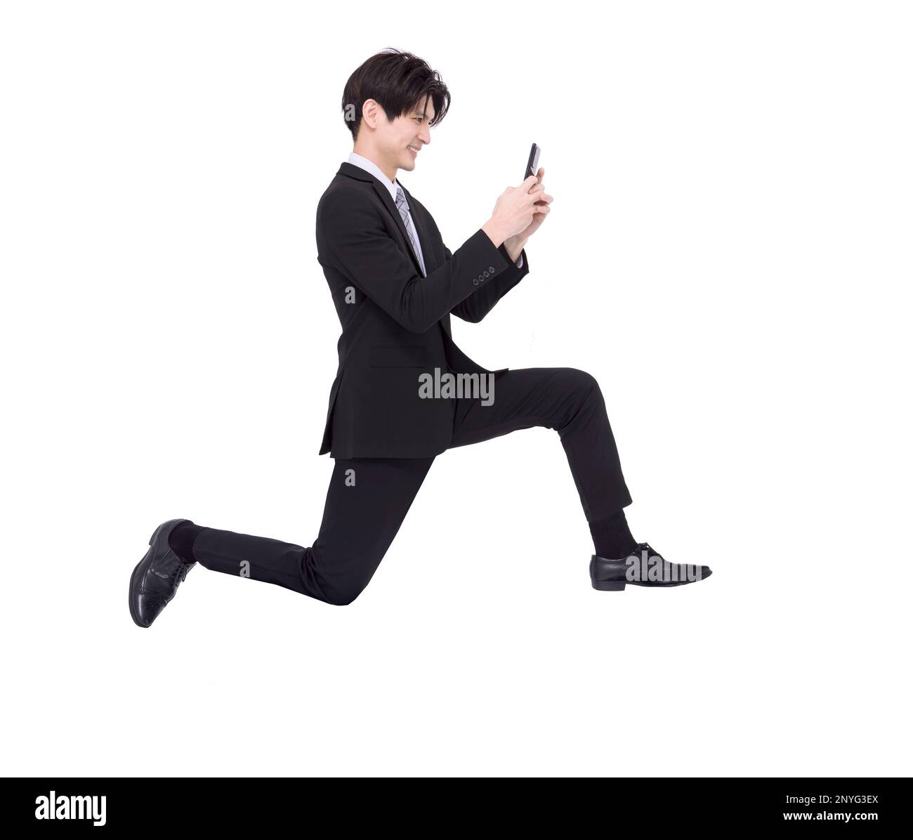 Vue latérale de l'homme d'affaires en train de courir et d'utiliser un téléphone mobile Banque D'Images