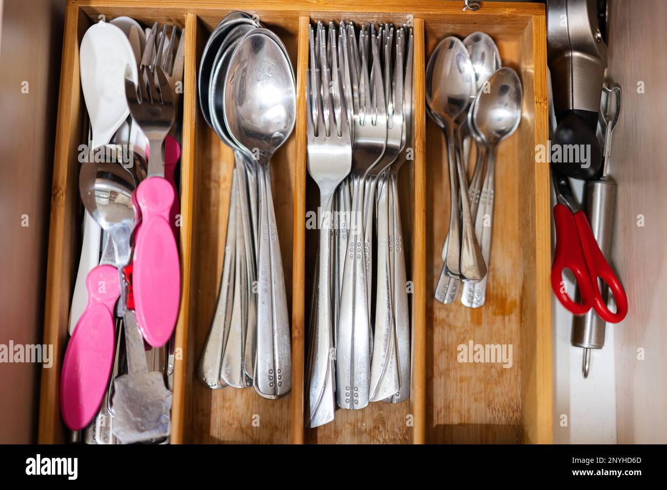 Cuillères propres et argentées, fourchettes au tiroir de cuisine avec set de couverts. Vue à plat du plateau de rangement avec kit simple d'ustensiles dans une boîte de rangement ouverte. Banque D'Images