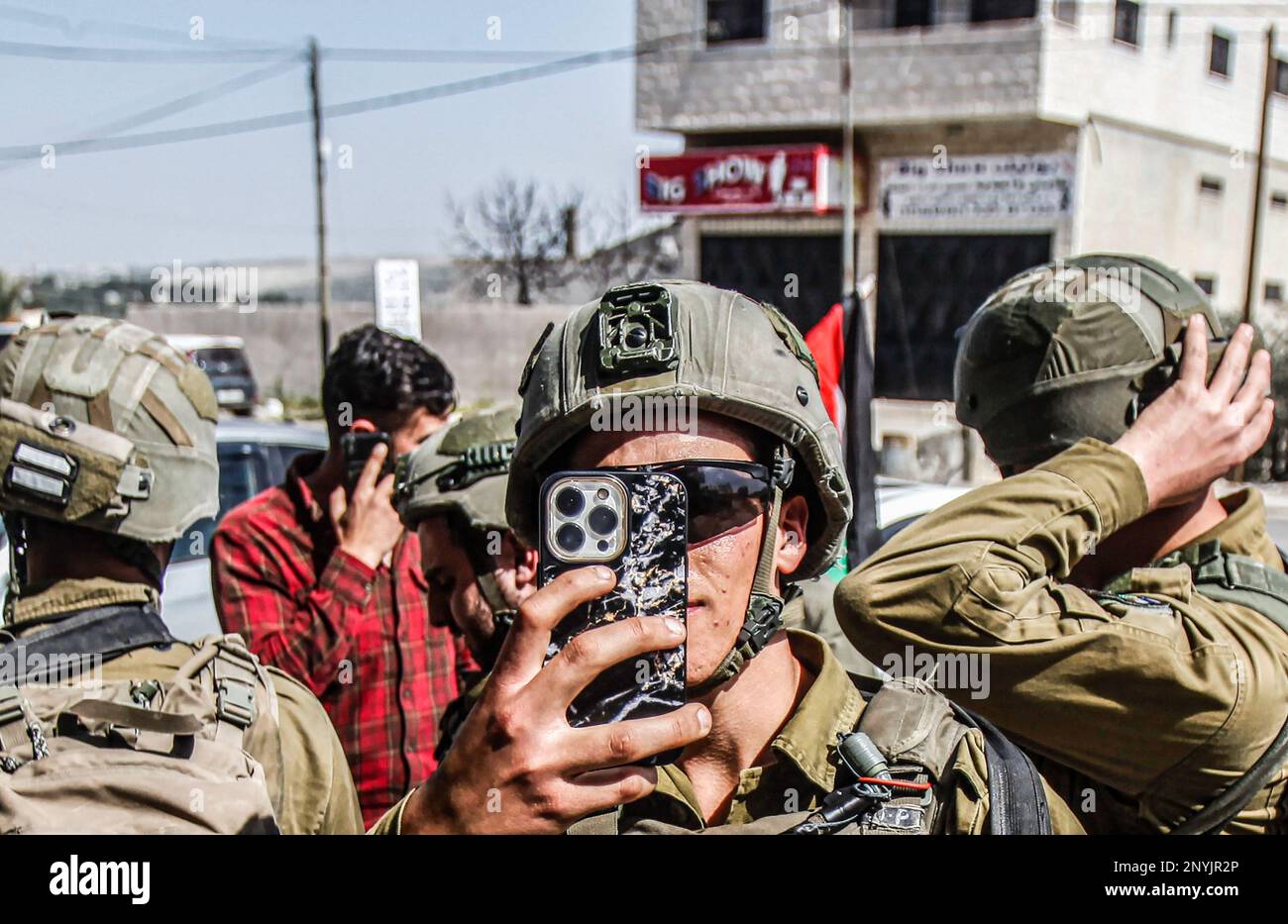 Naplouse, Palestine. 02nd mars 2023. Un soldat israélien prend des photos avec son téléphone, lors d'une manifestation contre les attaques des colons juifs et la fermeture des magasins commerciaux par l'armée israélienne dans la ville de Hawara, au sud de Naplouse, en Cisjordanie occupée. (Photo de Nasser Ishtayeh/SOPA Images/Sipa USA) crédit: SIPA USA/Alay Live News Banque D'Images