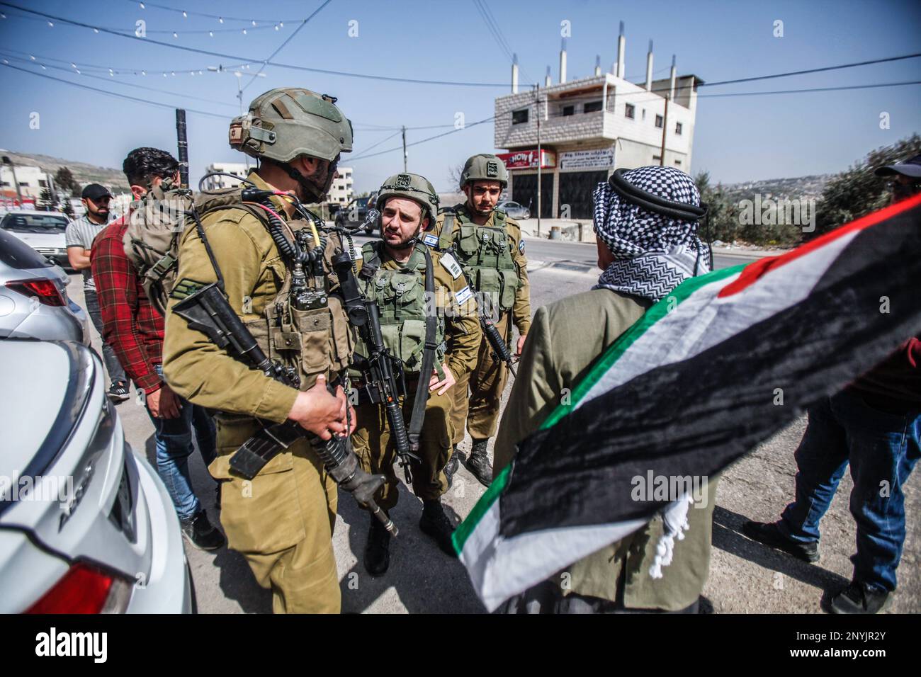Naplouse, Palestine. 02nd mars 2023. Un homme palestinien âgé fait passer le drapeau palestinien devant les soldats israéliens lors d'une protestation contre les attaques des colons juifs et la fermeture des magasins commerciaux par l'armée israélienne dans la ville de Hawara, au sud de Naplouse, en Cisjordanie occupée. (Photo de Nasser Ishtayeh/SOPA Images/Sipa USA) crédit: SIPA USA/Alay Live News Banque D'Images