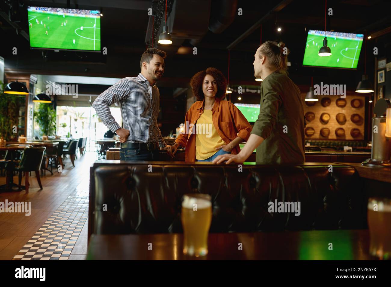 Groupe d'amis heureux se reposant et parlant au bar ou au pub Banque D'Images