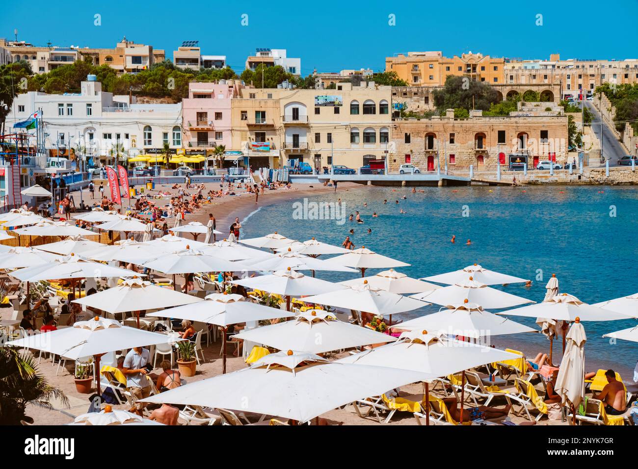 St Julians, Malte - 5 septembre 2022: Une foule de gens apprécient le bon temps d'une journée d'été sur la plage de la baie de St Georges, à St Julians, Malte Banque D'Images