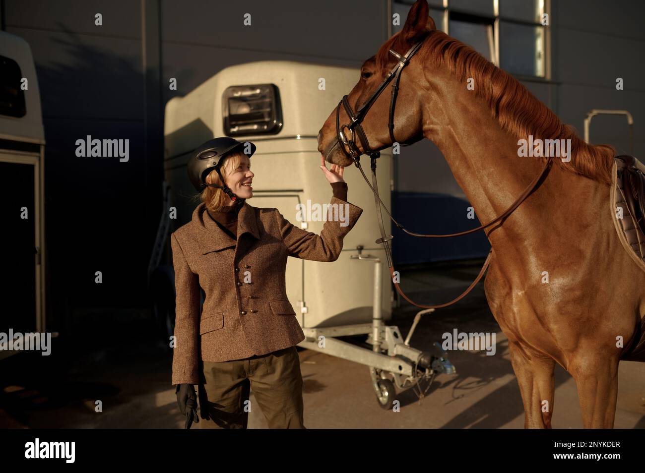 Jeune adulte rider souriant femme qui a le nez d'un cheval Banque D'Images