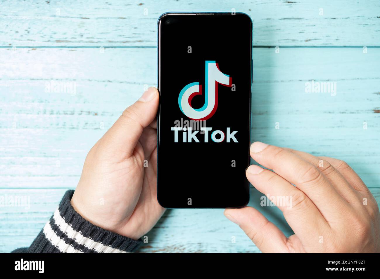 Zhongshan China-2 mars,2023:man tenant un mobile avec un grand logo TikTok à la composition horizontale. Banque D'Images