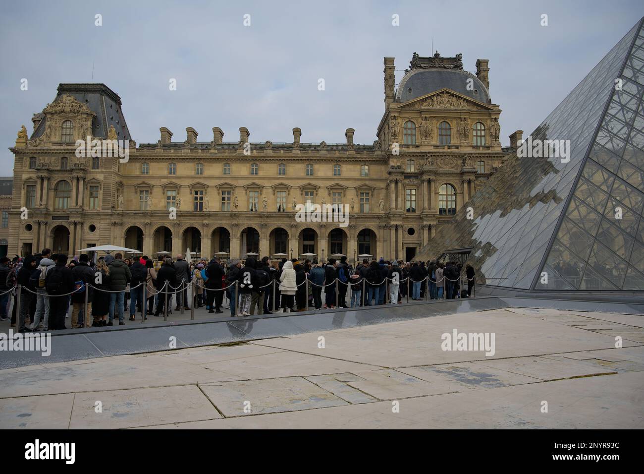 De grandes foules font la queue à l'extérieur de la pyramide du Louvre Banque D'Images