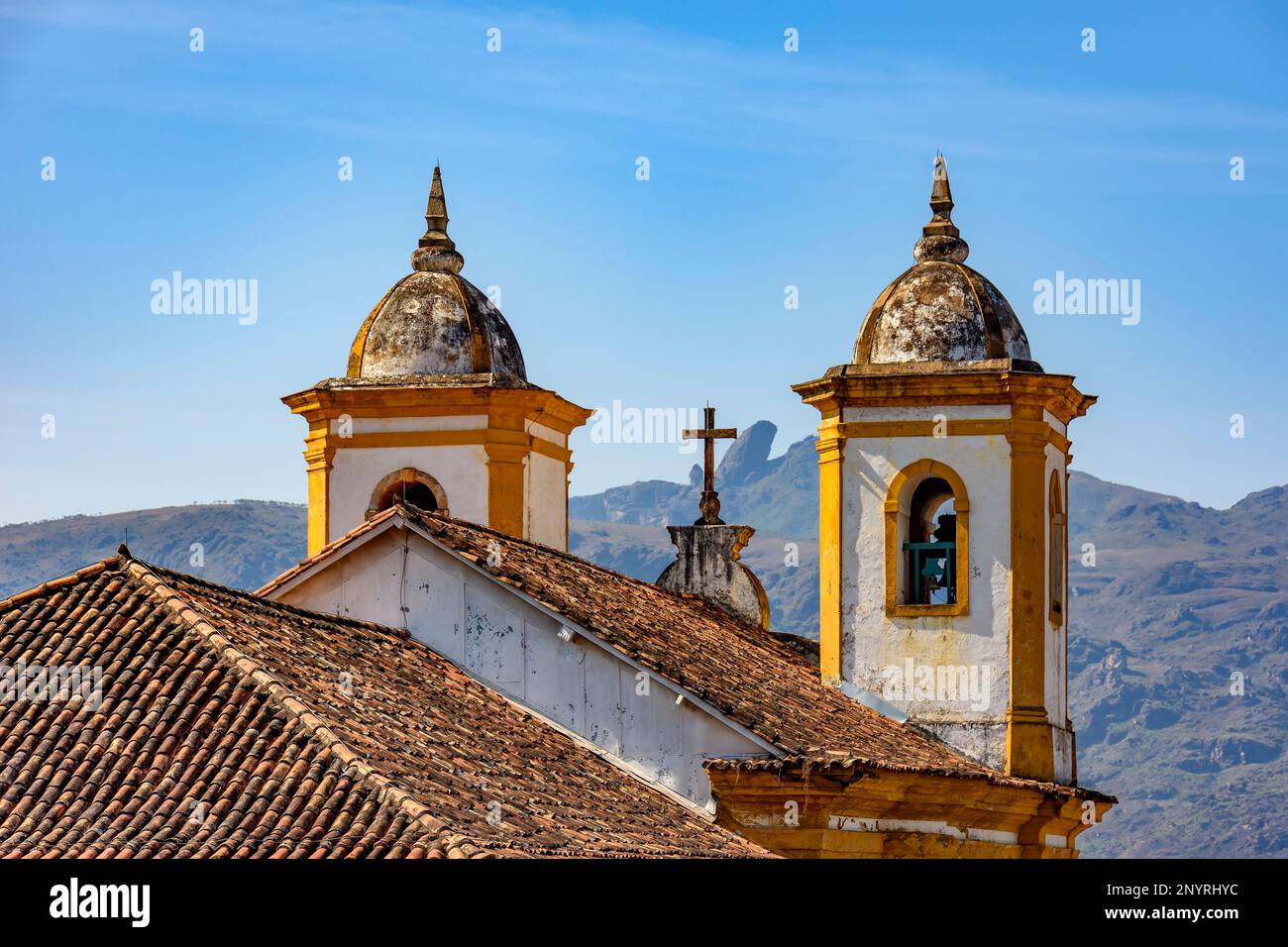 Clochers d'une ancienne église baroque dans la ville d'Ouro Preto au coucher du soleil avec les montagnes en arrière-plan Banque D'Images