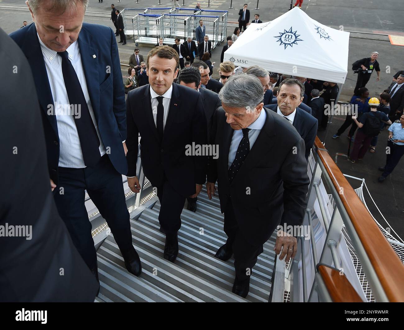 French President Emmanuel Macron, center, and Mediterranean Shipping Company (MSC) Chairman Gianluigi Aponte, right, walk up a gangway during the delivery ceremony of the MSC Meraviglia cruise ship at the STX shipyard of Saint-Nazaire, western France, Wednesday, May 31, 2017. With a capacity of 65700 passengers and 1550 crew members, the MSC Meraviglia is the biggest cruise ship in Europe. (Jean-Sebastien Evrard/Pool Photo via AP) Banque D'Images