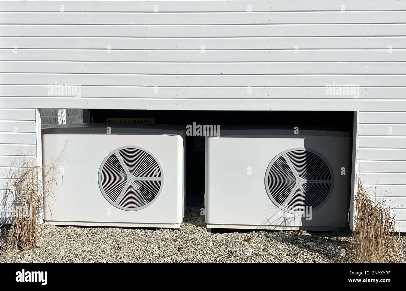 Pompes à chaleur récemment installées fournissant de l'énergie propre devant une maison. Le thème de la transition énergétique et de la hausse des prix de l'électricité. Banque D'Images