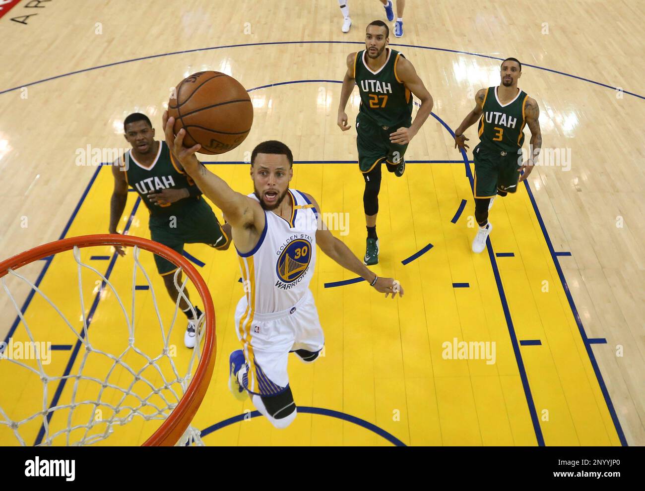 Golden State Warriors' Stephen Curry (30) drives to the basket past Utah Jazz's Joe Johnson, left, Rudy Gobert (27) and George Hill (3) during the second half in Game 1 of an NBA basketball second-round playoff series, Tuesday, May 2, 2017, in Oakland, Calif. (Ezra Shaw/Pool Photo via AP) Banque D'Images