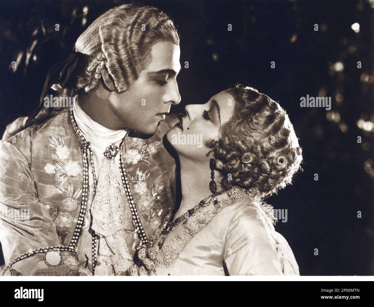 1924 , USA : l'acteur de cinéma sur écran silencieux RUDOLPH VALENTINO ( né Rodolfo Guglielmi , 1895 - 1926 ), avec DORIS KENYON à MONSIEUR BEAUCAIRE de Sydney Olcott , du roman de Booth Tarkington , Costume de George Barbier - CINÉMA MUTO - RODOLFO - attore camografico - neo - mole - col - colletto - LATIN AMANT - italoamericano - italo americano - italo-americano - émigrant - emigrante - italo-américain - portrait - ritto - parrucca - perruque - profilo - KISS - profil - BACIO - boucles - boccoli - riccioli - Collo - cou - étreinte - abbraccio - ricamo - cousus - orecchini - orecchino Banque D'Images