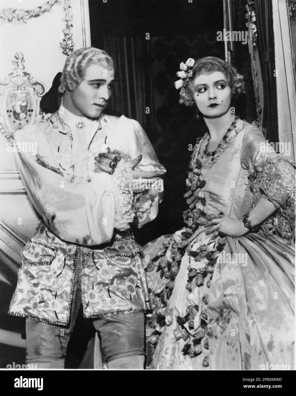 1924 , USA : l'acteur de cinéma sur écran silencieux RUDOLPH VALENTINO ( né Rodolfo Guglielmi , 1895 - 1926 ), avec DORIS KENYON à MONSIEUR BEAUCAIRE de Sydney Olcott , du roman de Booth Tarkington , Costume de George Barbier - RODOLFO - CINÉMA MUTO - attore camografico - neo - mole - collier - colletto - LATIN AMANT - italioamericano - italo americano - italo-americano - émigrant - emigrante - italo-américain - portrait - ritto - parrucca - perruque - curls - riccicoli - riccicoli - collo - cou - ricamo - cousus - bracelet - braccialetto - bijoux - gioiello - gioielli - bijoux - Banque D'Images