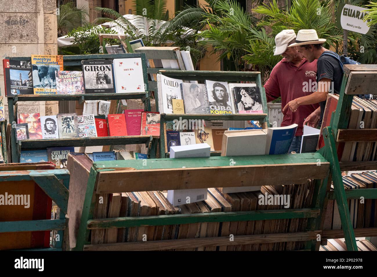 Cubains regardant des livres de seconde main sur les héros de la Révolution cubaine et Che Guevara dans une boîte de livres en plein air à Plaza de Armas, la Havane, Cuba Banque D'Images