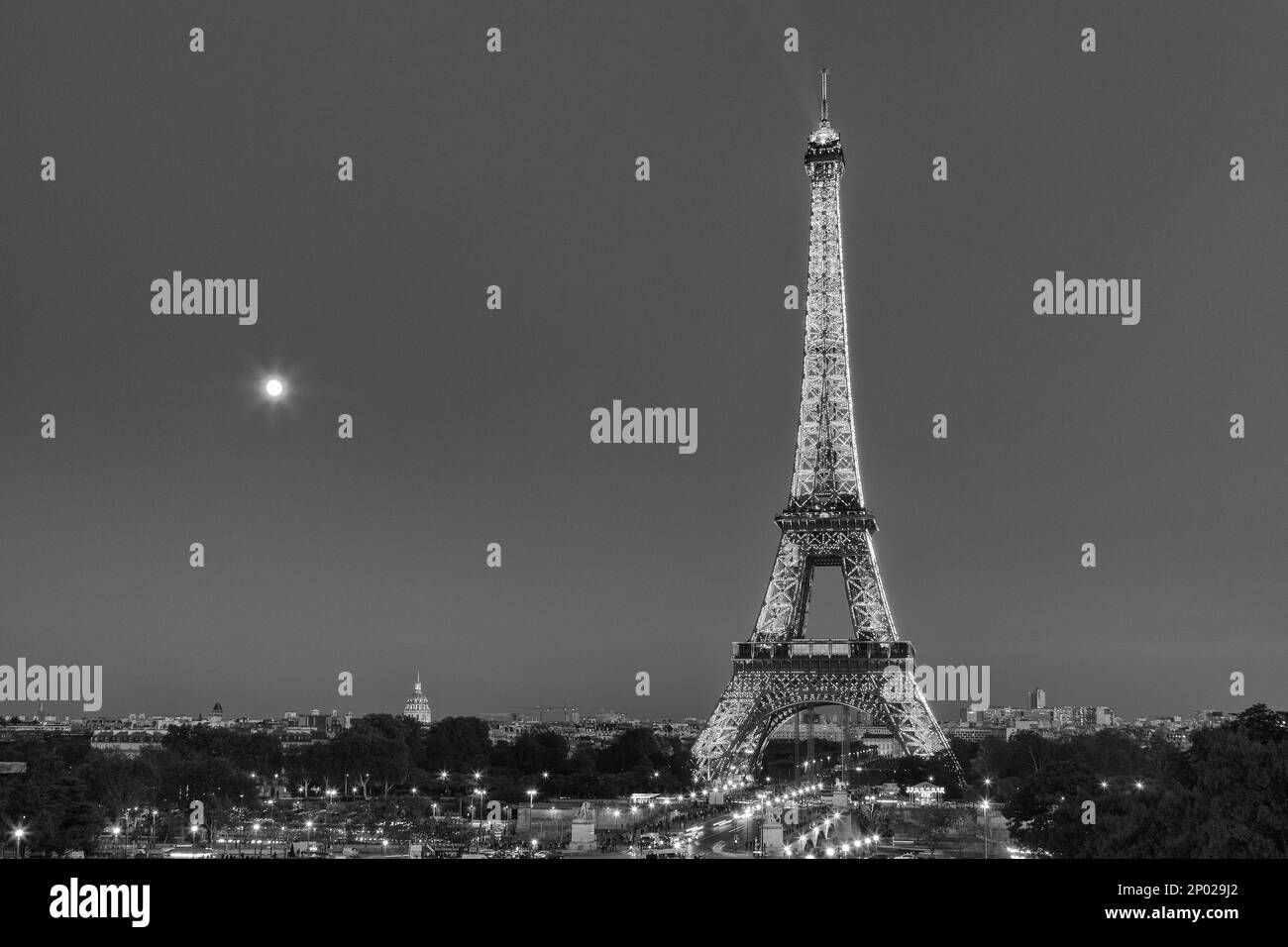 Feux de signalisation menant à une Tour Eiffel illuminée la nuit à Paris, France Banque D'Images