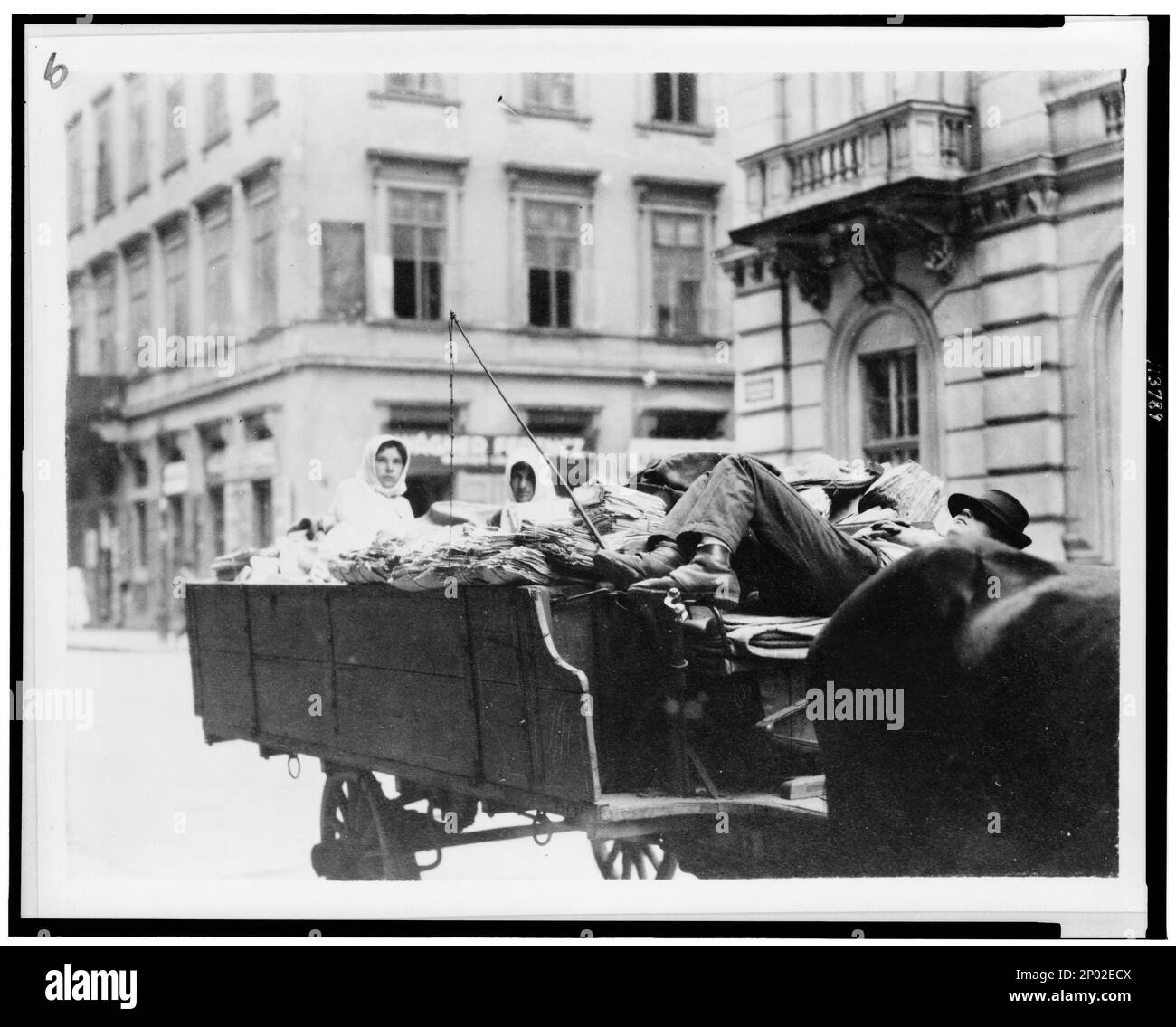 Homme couché sur un siège de wagon, deux femmes à l'arrière du wagon, Hongrie. Collection Frank and Frances Carpenter, chariots et wagons, Hongrie, 1920-1930. Banque D'Images