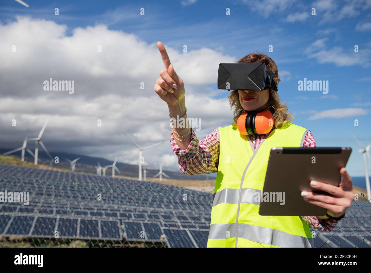 Une femme ingénieure de la ferme solaire utilise les micro-casques de réalité virtuelle et la tablette. Banque D'Images