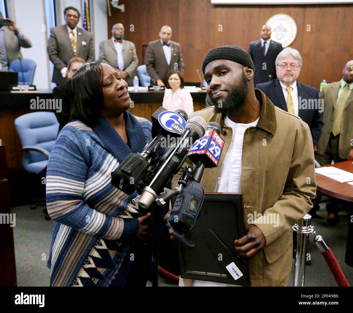 Ibn Ali Miller speaks as his mother Sabrina Winters, left, looks on at an Atlantic City Council meeting where he was honored Wednesday March 22, 2017, in Atlantic City, N.J. Millar, a New Jersey man who interrupted a street fight between two teenagers in a video that has drawn millions of views and wide praise, said Wednesday that he's saddened that his act of peacemaking isn't a more frequent occurrence. (Edward Lea/The Press of Atlantic City via AP) Banque D'Images