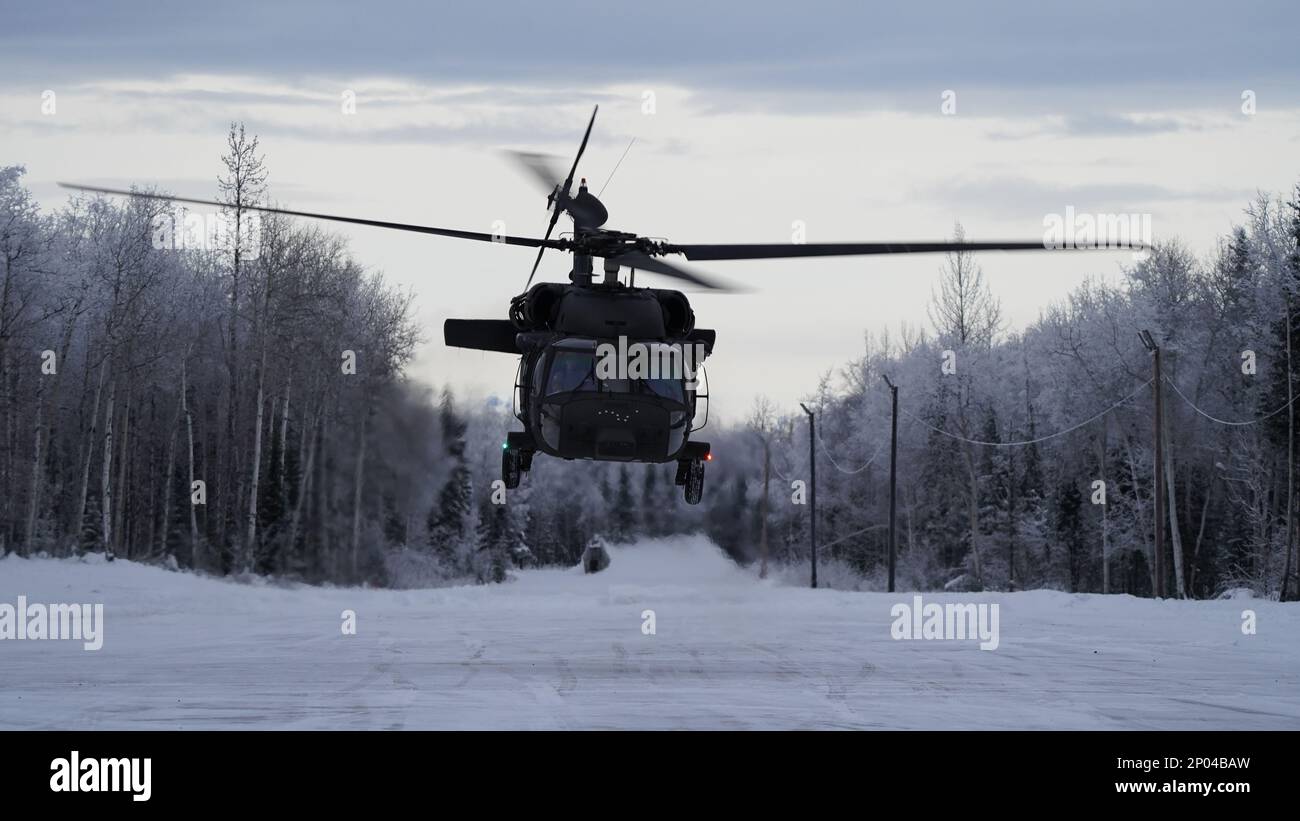 Un hélicoptère de la Garde nationale de l'Armée de l'Alaska UH-60L Black Hawk, affecté au 1-207th Aviation Regiment, se lève du Camp Mad Bull sur la base conjointe Elmendorf-Richardson, Alaska, le 10 janvier 2023. L'équipage a mené une formation d'insertion aérienne avec les 24th équipes de tactiques spéciales de l'escadre des opérations spéciales. Le bataillon de soutien général de l’aviation de la Garde nationale de l’Armée de l’Alaska s’entraîne régulièrement avec toutes les branches de l’armée et les organismes civils pour accroître son interopérabilité opérationnelle et être prêt à accueillir une vaste gamme de missions fédérales et d’État. Banque D'Images