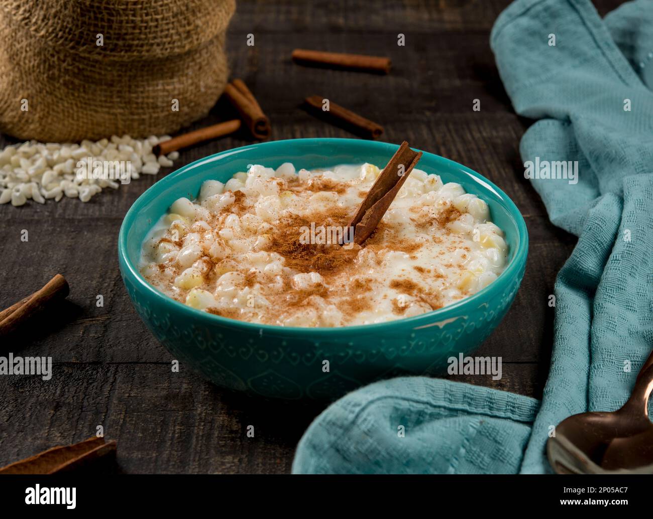 plat brésilien typique canjica hominy à la cannelle dans un pot bleu en bois sombre. Banque D'Images