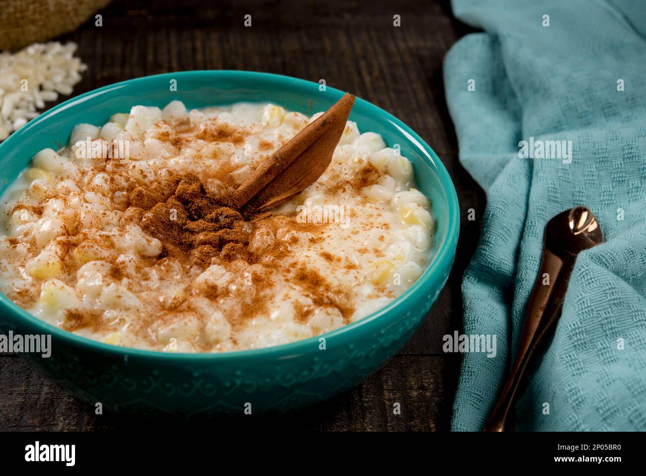 plat brésilien typique canjica hominy à la cannelle dans un pot bleu en bois sombre. Banque D'Images