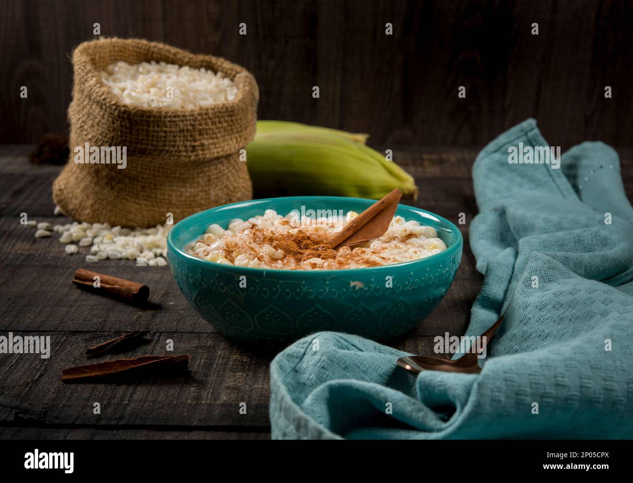 plat brésilien typique canjica hominy à la cannelle dans un pot bleu en bois sombre. Banque D'Images