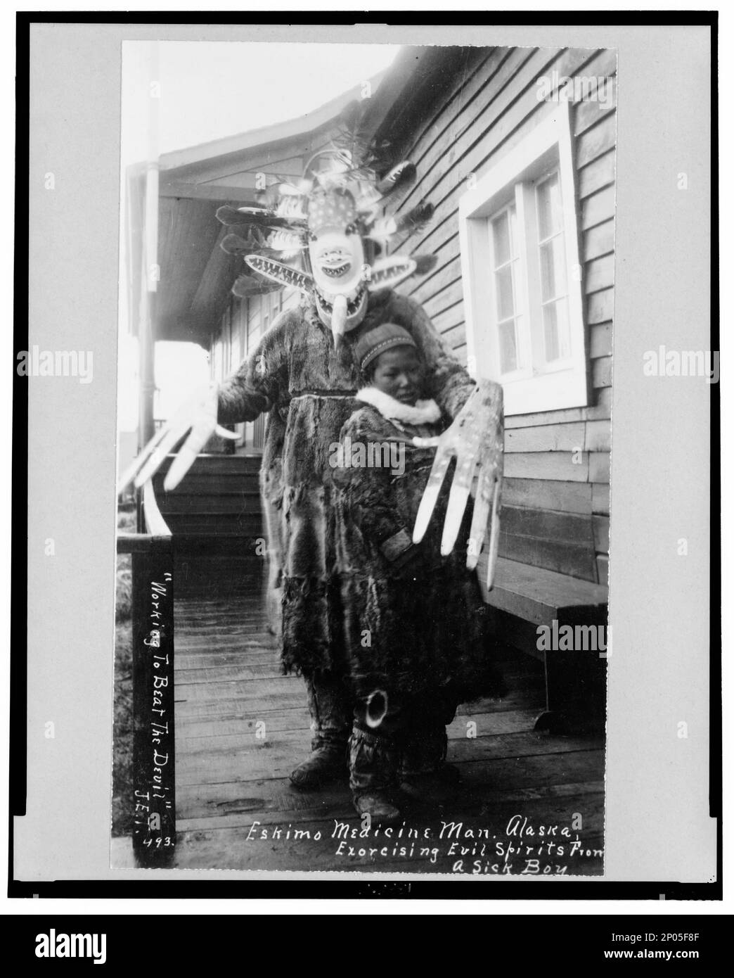 Eskimo Medicine man et malade garçon , 'travailler pour battre le diable' - Eskimo Medicine man exorciser les mauvais esprits d'un garçon malade. Collection Frank and Frances Carpenter , Don; Mme W. Chapin Huntington; 1951, Esquimos,vie spirituelle,Alaska,1890-1940, Indiens d'Amérique du Nord,vie spirituelle,Alaska,1890-1940, shamans,Alaska,1890-1940, garçons,Alaska,1890-1940, masques,Alaska,1890-1940, États-Unis,Alaska Banque D'Images