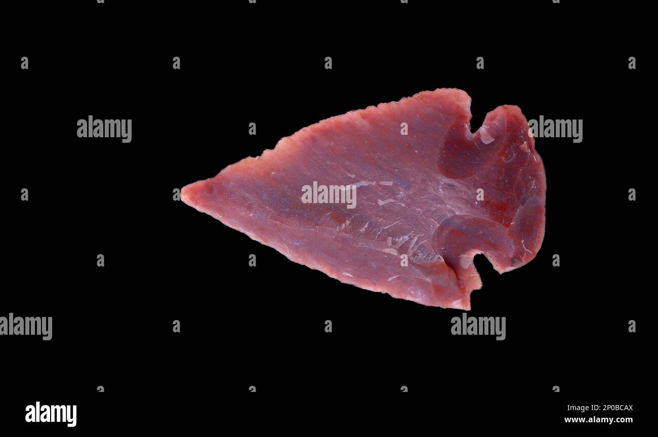 Ancienne flèche primitive de pierre préhistorique isolée sur noir Banque D'Images