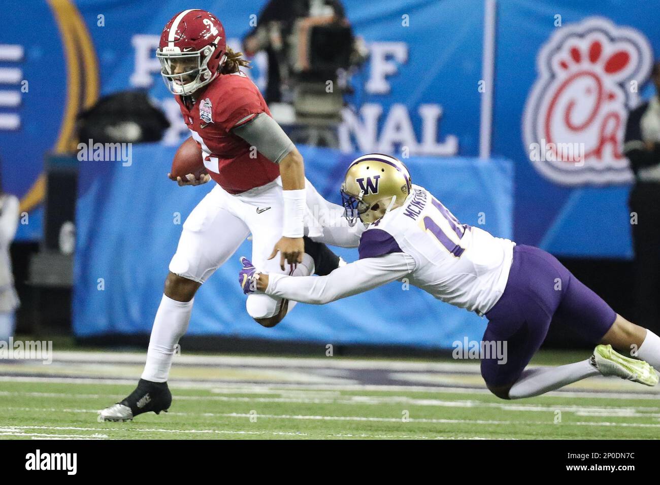 ATLANTA, GA - DECEMBER 31: Washington Huskies defensive back Jojo McIntosh (14) trips up Alabama Crimson Tide quarterback Jalen Hurts (2) during the Semi-Final Peach Bowl game between the Washington Huskies and the Alabama Crimson Tide on December 31, 2016 at the Georgia Dome in Atlanta, GA. Alabama defeated Washington 24-7.(Photo by Jim Dedmon/Icon Sportswire) (Icon Sportswire via AP Images) Banque D'Images